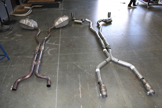 Stock exhaust on the left, new SLP undercar pieces on the right. We like that the SLP system gives the ability to remove the first set of mufflers and replace them with straight pipes should the need (or want) arise in the future.