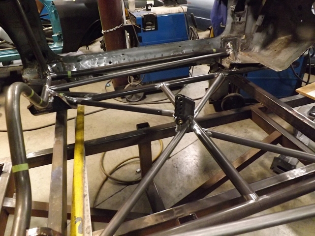 Here you can see the engineering PMR is putting into the chassis build. The frame rails (as part of the 25.3) actually tie directly into the front and rear frame rails of the stock Camaro chassis. The x-brace – also 25.3 required – ties into the torque arm. The rear control arm mounting locations tie into the stock frame, stock frame rails in rear, and to the 25.3 frame rails and #1 bar. It’s a tightly integrated package. You can see better now how the floorpan is going to  reinstalled. The frame rails will go below the floorpan, the #1 bar and the rocker bars will go above.