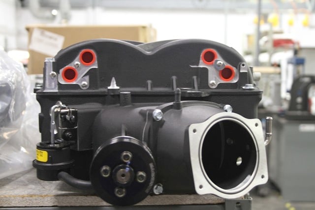 Front view of a Magnuson Heartbeat supercharger - note the dual intercooler core inlets and outlets on either side of the cover, and the bypass valve actuator on the left hand side of the case.