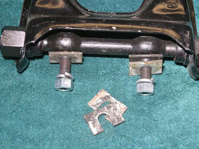An example on an outboard-mounted upper control arm showing the shims used to adjust caster and camber. When two shims of the same thickness are installed or removed, camber is adjusted. If the shims are of different thicknesses, both caster and camber will be affected. Image by author. 