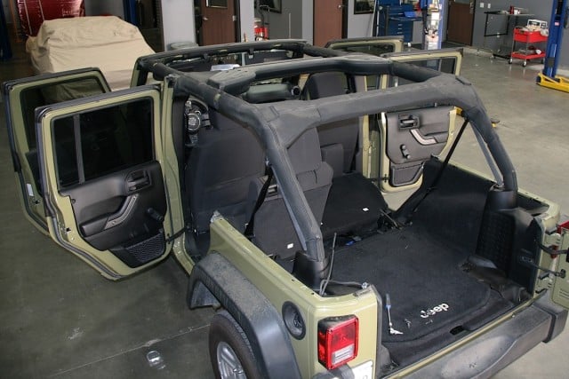 Sarge looked rather naked without a cap, but the factory hardtop had to removed before we could begin installation of the Bestop Black Twill Trektop NX.