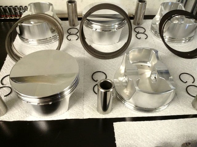Seen here are the crowns and underside of the BLS1010 CP Pistons along with the rings, chro-moly wrist pins and round wire pin locks. The pistons are manufactured in the USA from 2618 alloy for strength and durability using a finite element analysis designed forging featuring dual forced pin oiling and are balanced to plus or minus 1 gram. 