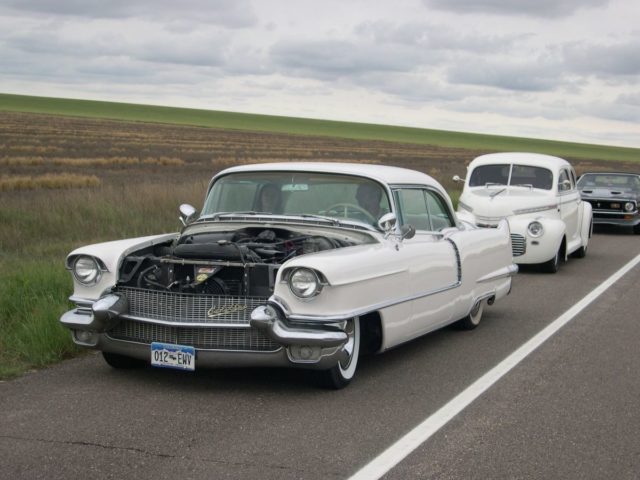 The '56 still in its Earl Schieb paint job and after the hood was replaced (and primed in white) and Ford "Cruiser" skirts were made to fit. Lakes Pipes were added.
