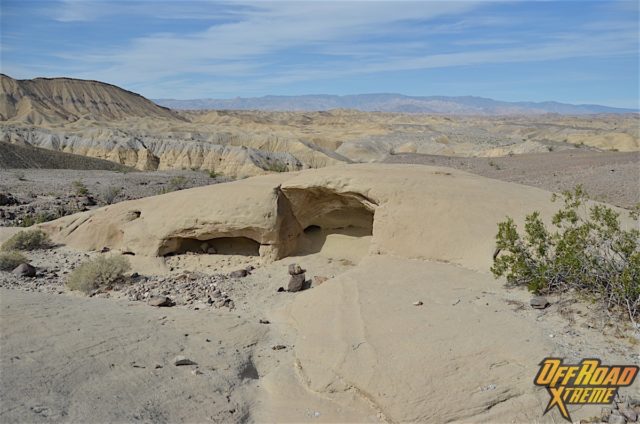 One of the wind caves in the foreground and the vast desert landscape in the back.