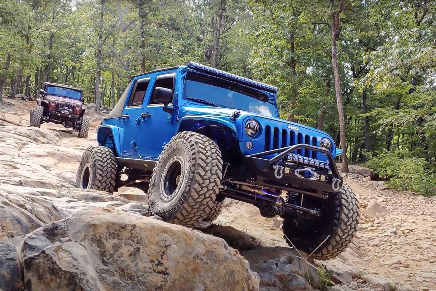 Blue jeep running over some ExtremeTerrain