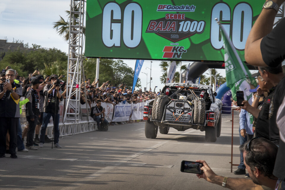 The #87 Trophy Truck tears off the start line at the 2023 Baja 1000 race.